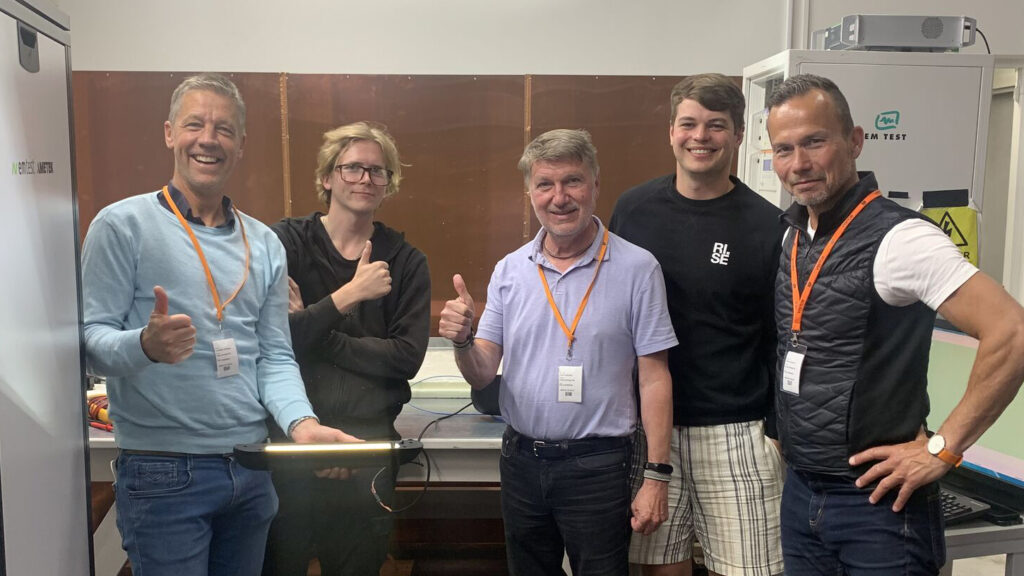 5 män står uppställda i en verkstad