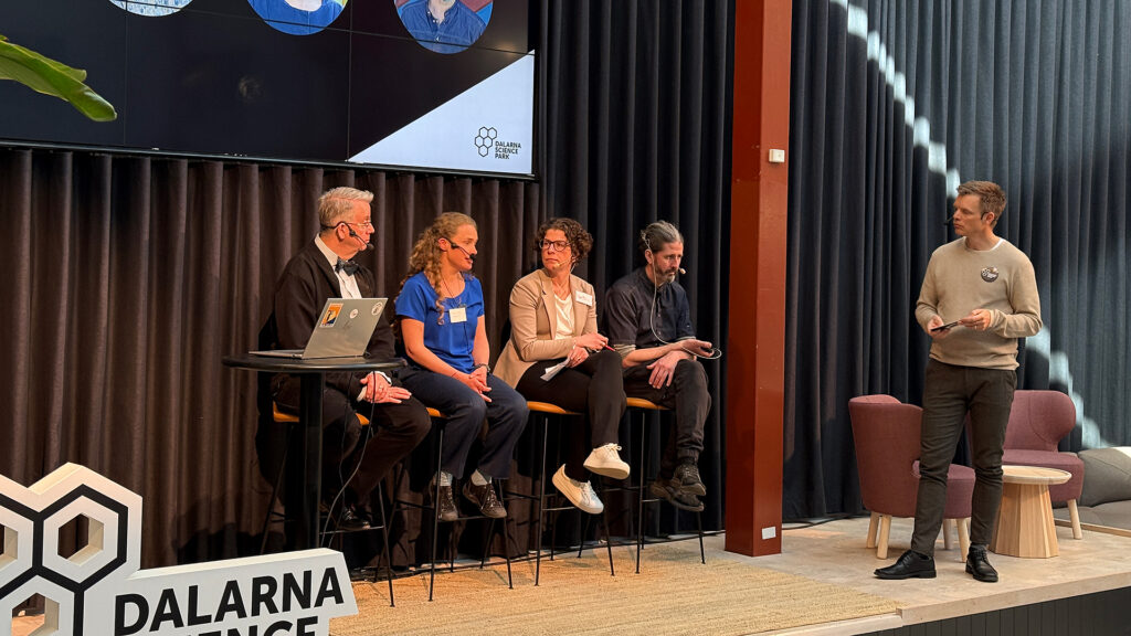 Deltagare i en paneldiskussion på scenen