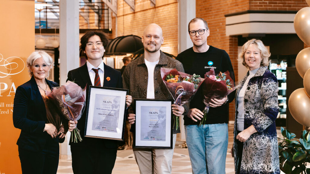 Tre pristagare av SKAPA-priset Dalarna 2026 med blommor och diplom, omringade av två nyckelpersoner som var prisutdelalare.